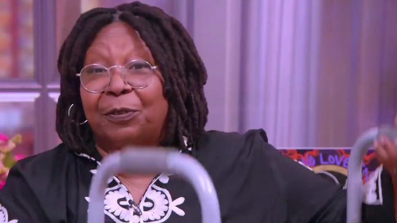 Whoopi Goldberg holding a walker