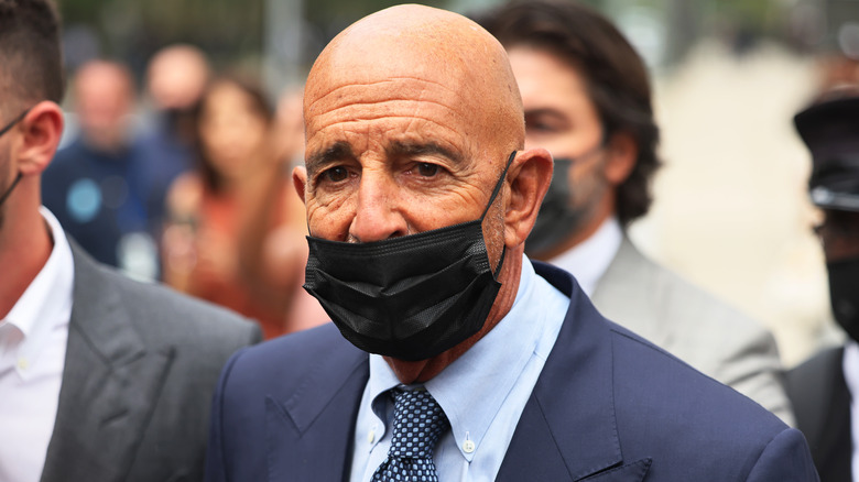 Tom Barrack leaving court wearing suit and face mask