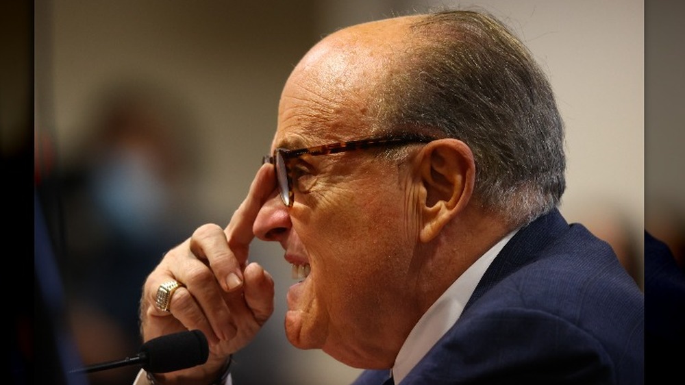 Rudy Giuliani adjusts his glasses