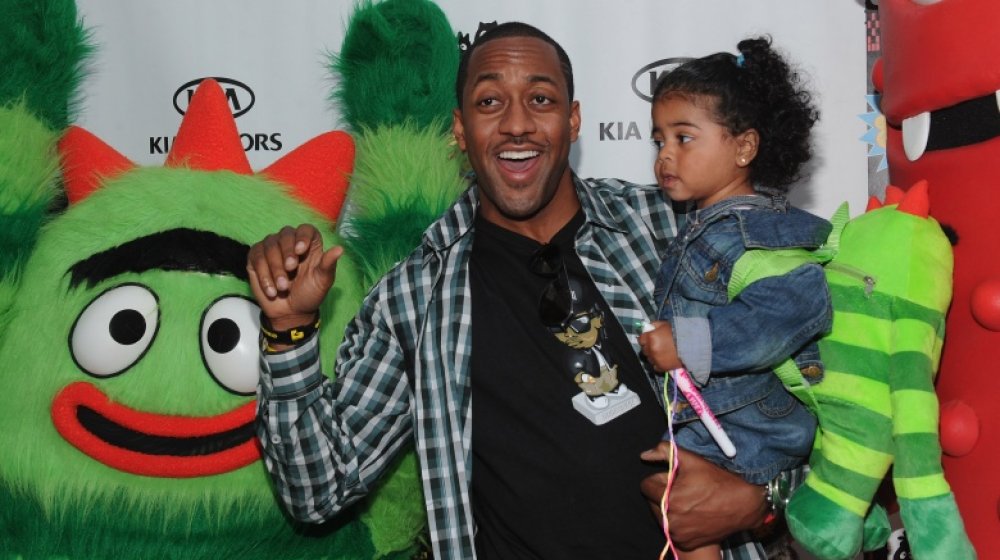 Jaleel White smiling and holding his daughter at a Yo Gabba Gabba! event in 2010