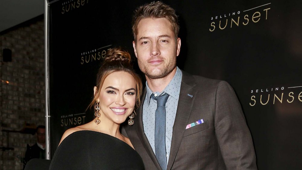 Chrishell Stause, Justin Hartley posing at Selling Sunset premiere
