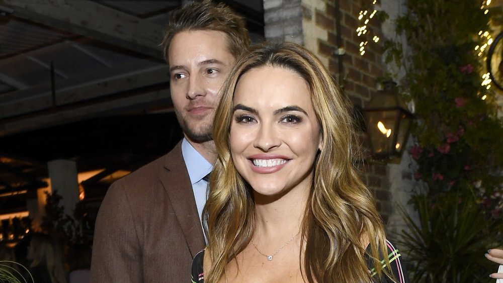 Chrishell Stause standing in front of Justin Hartley