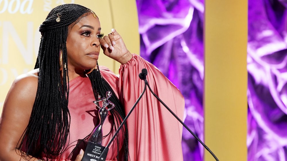 Niecy Nash wiping a tear while accepting an award at Essence's Black Women in Hollywood Awards