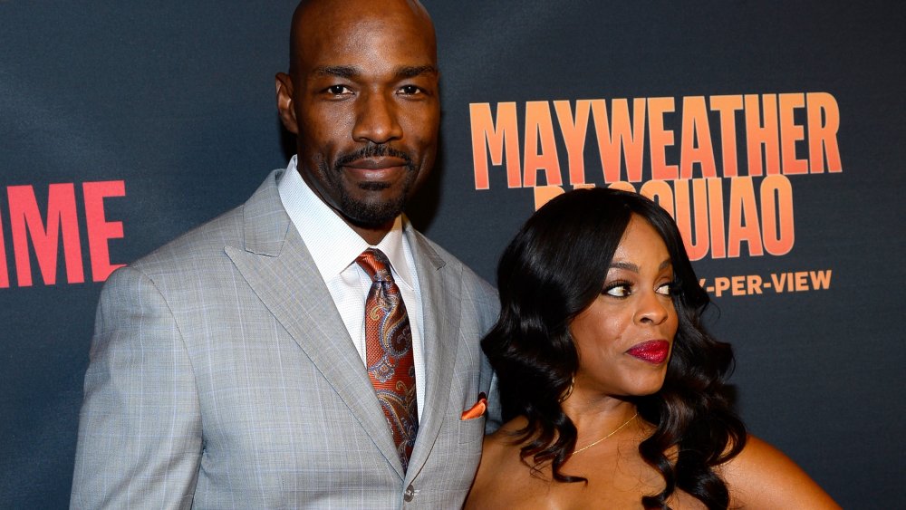 Jay Tucker, Niecy Nash looking in different directions at a movie premiere