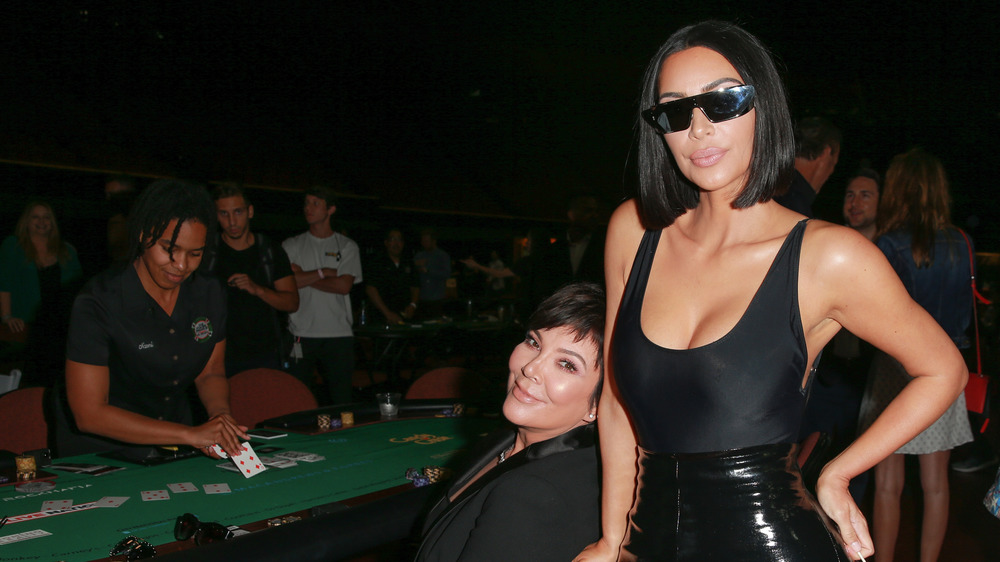 Kris Jenner and Kim Kardashian at poker table posing in black