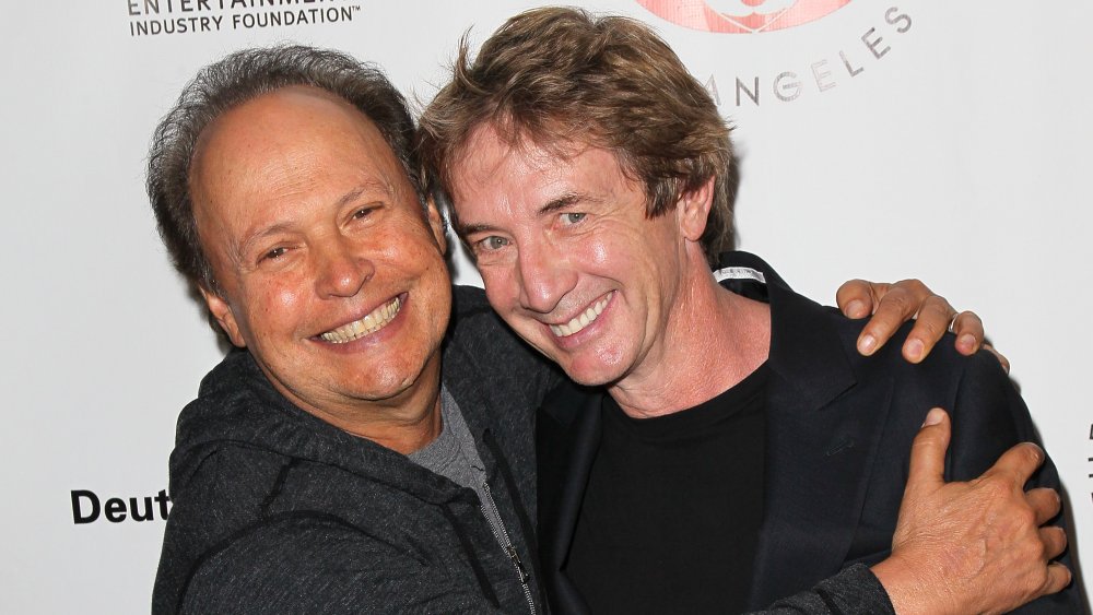 Billy Crystal and Martin Short smile and embrace on the red carpet