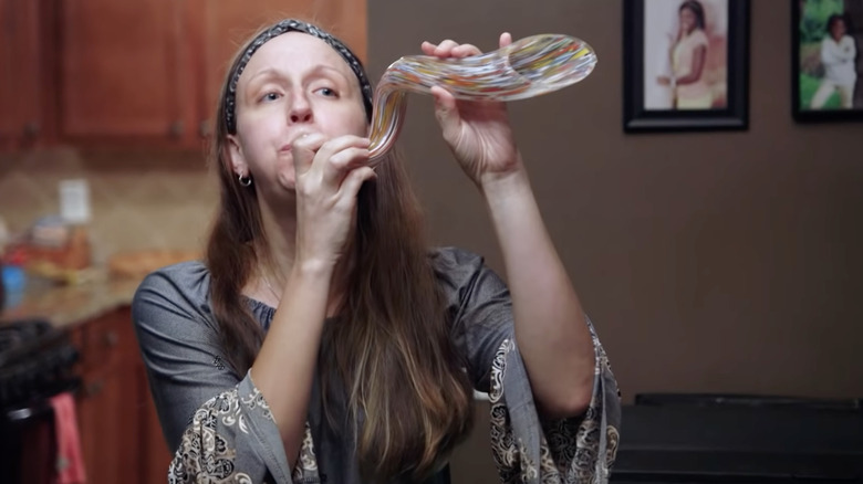 Woman using glass-blown art instrument