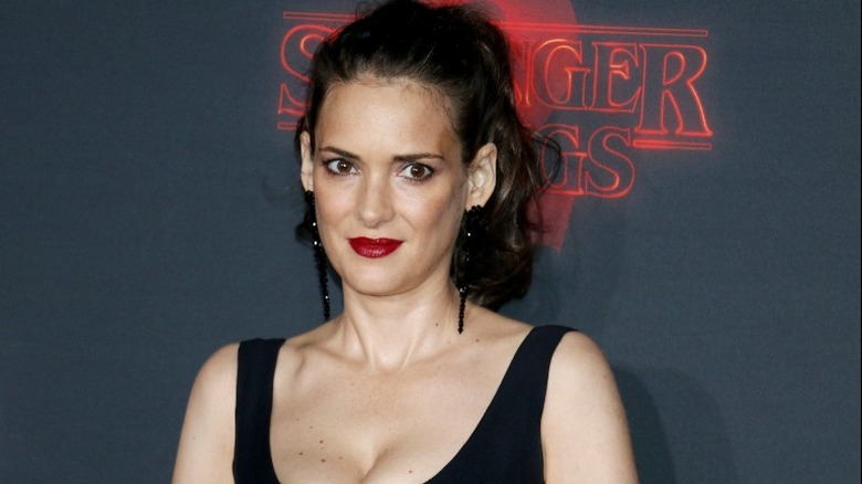 Winona Ryder smiling on red carpet in red lipstick 