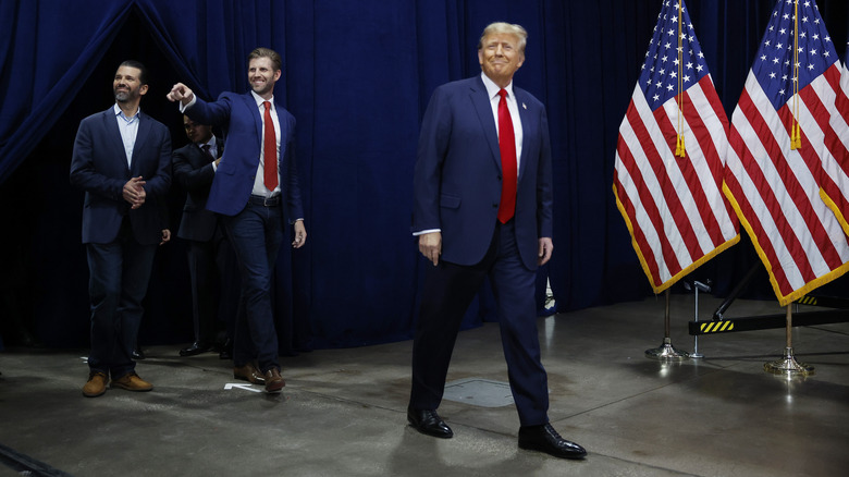 Donald Trump walks on stage followed by Eric Trump and Donald Trump Jr.