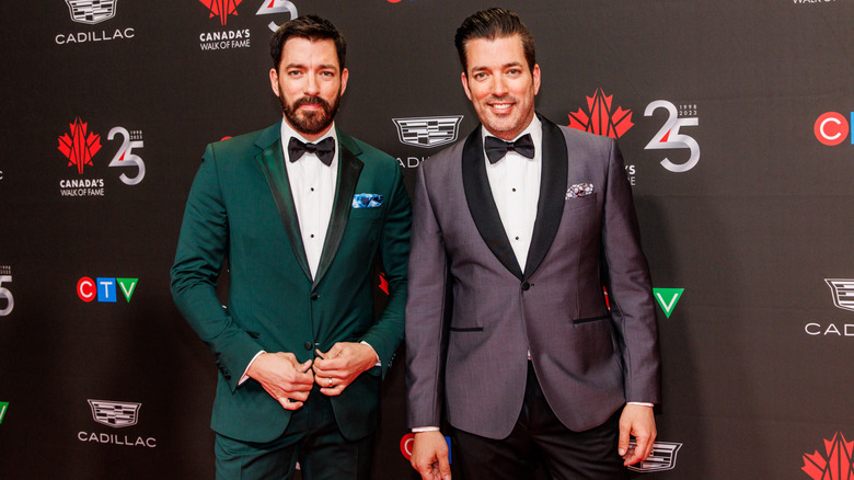 The Property Brothers posing on the red carpet in green and purple jackets with bowties