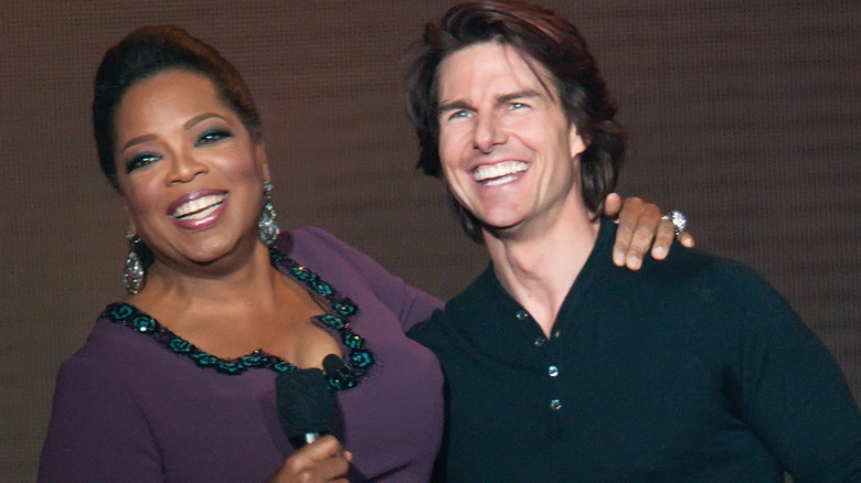 Oprah Winfrey and Tom Cruise at an event, smiling