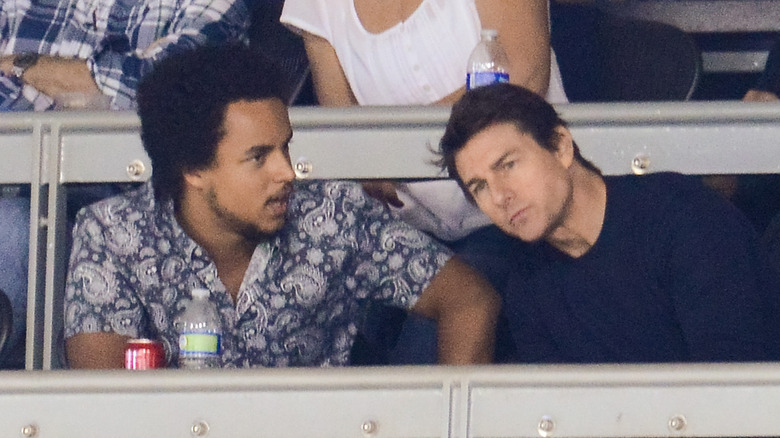 Connor and Tom Cruise at a sports event, seated