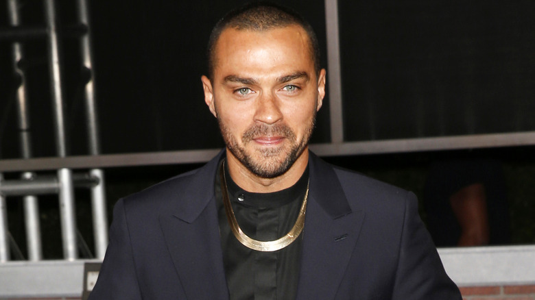 Jesse Williams buttons a black suit