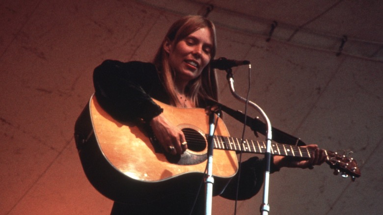 Joni Mitchell playing acoustic guitar