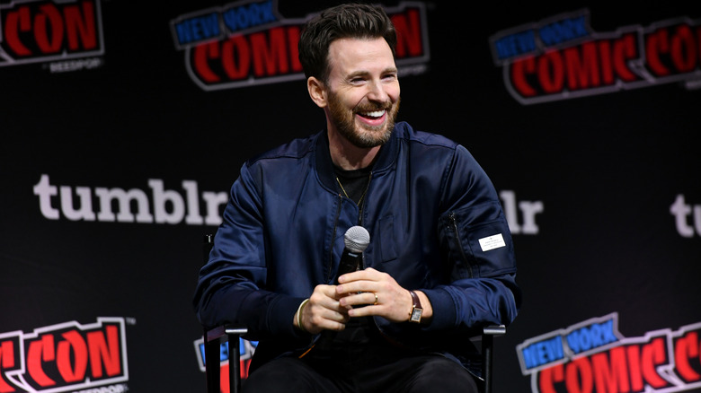 Chris Evans laughing with microphone on stage