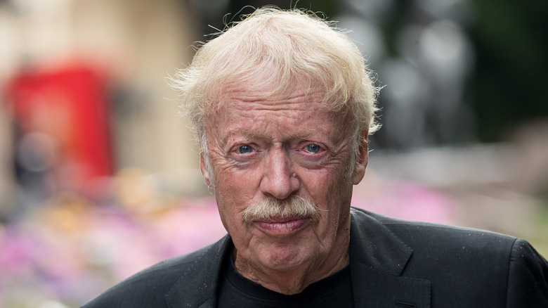 Phil Knight in a black shirt and jacket