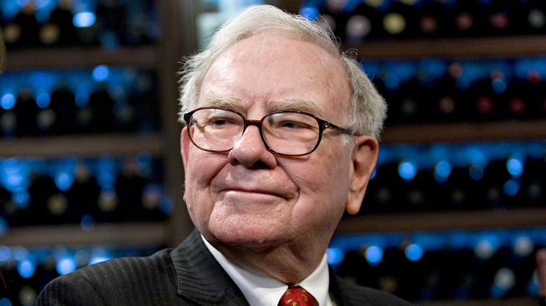 Warren Buffett in front of wine bottles
