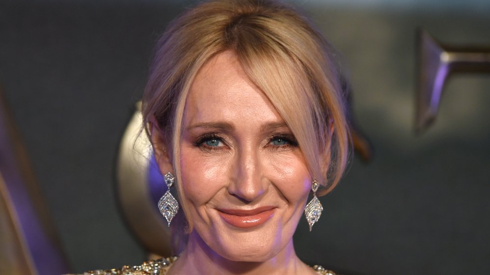 J.K. Rowling in a gold sparkly dress, smiling with her hair up