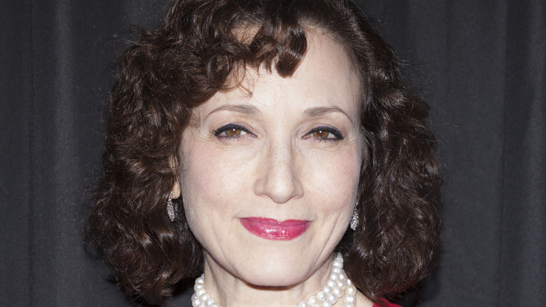 Bebe Neuwirth smiling in pearl necklace