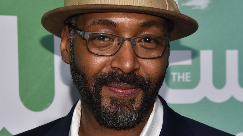 Jesse L. Martin smiling in brown fedora