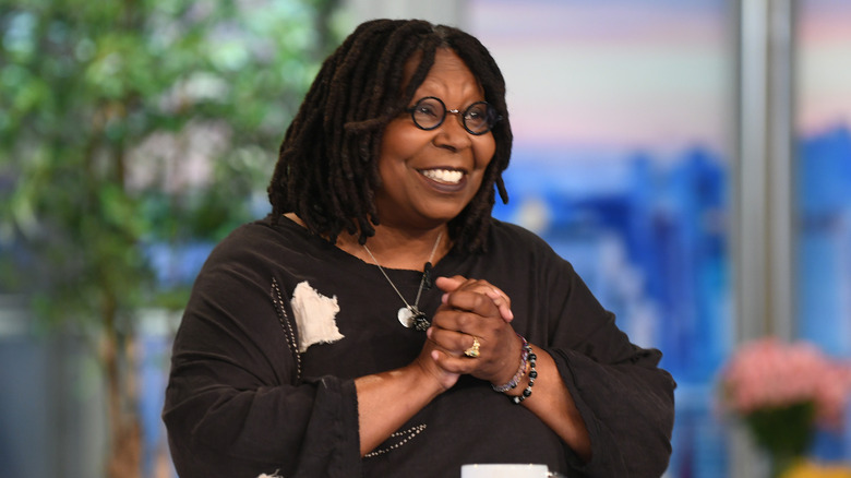 Whoopi Goldberg sitting at desk