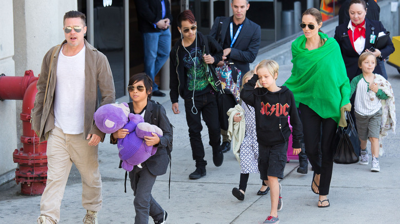 Brad Pitt, Angelina Jolie, and their children disembarking from a private jet