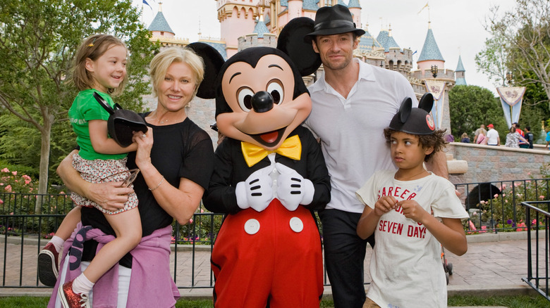 Hugh Jackman posing with his wife and kids at Disney