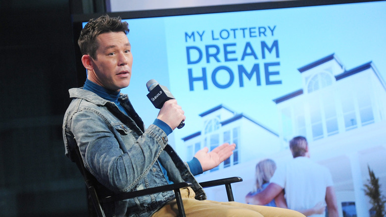 David Bromstad speaks in front of a screen showing "My Lottery Dream Home"