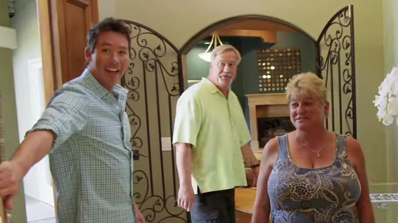 David Bromstad leads a man and a woman into a new house