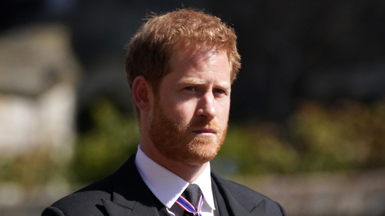 Prince Harry looking solemn in black suit