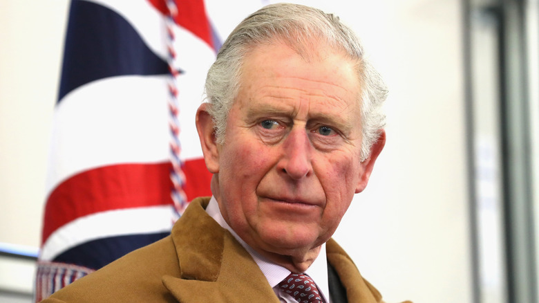 King Charles pictured in front of a British flag