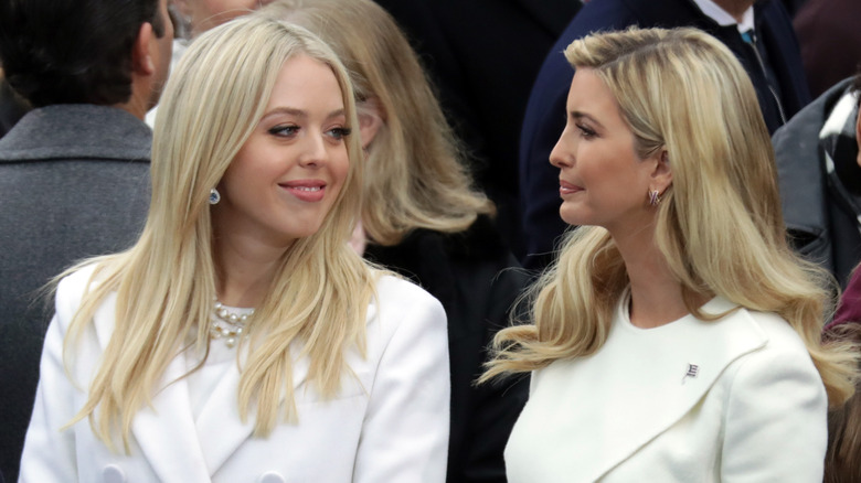 Tiffany Trump smiles at Ivanka Trump as her older sister pats her arm at Donald Trump's inauguration.