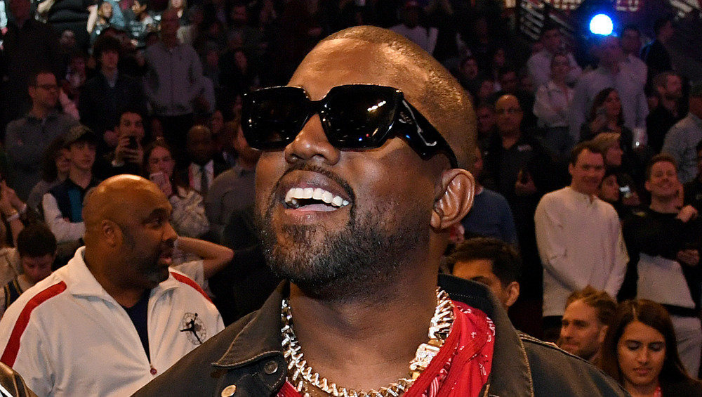 Kanye West smiling at a basketball game