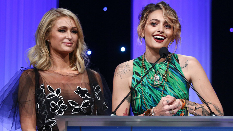 Paris Jackson and Paris Hilton smiling onstage 