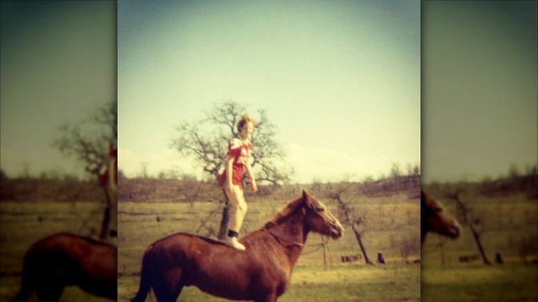 Reba McEntire standing on a horse