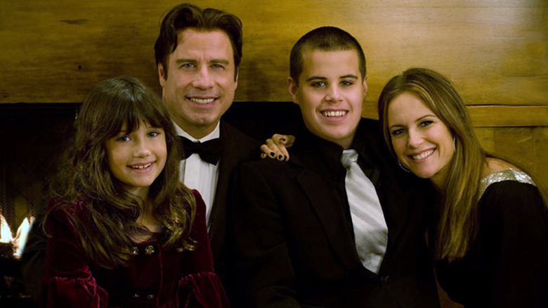 The Travolta family in front of fireplace