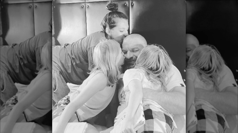 Paul "Triple H" Levesque hugging daughters Aurora, Murphy, Vaughn