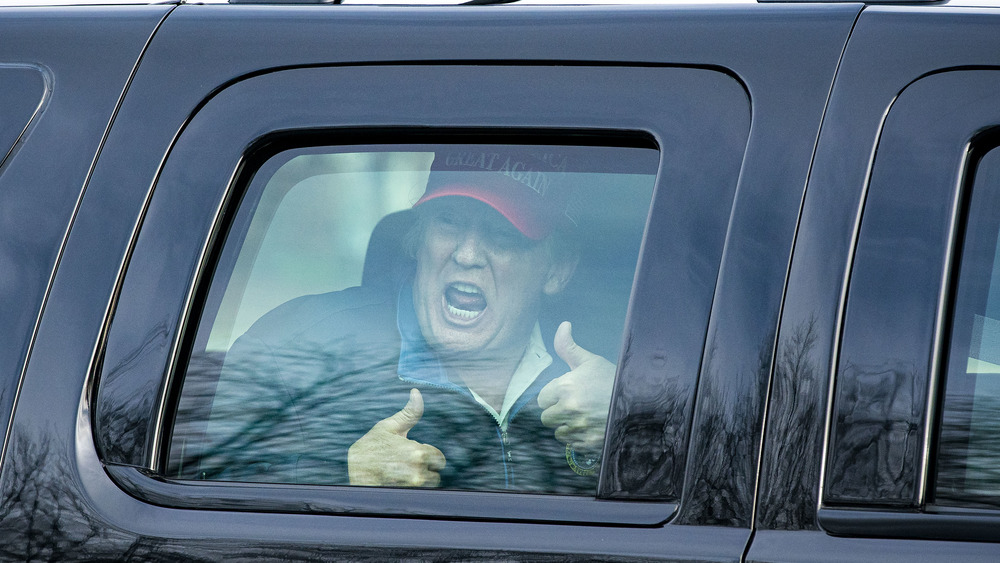 Donald Trump gestures in secure car