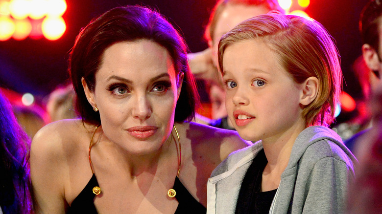 Shiloh Jolie-Pitt glancing sideways beside Angelina Jolie