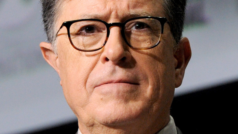 Stephen Colbert frowning brown rim glasses