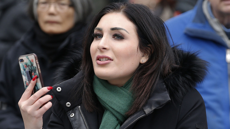 Laura Loomer holding her phone