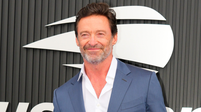 Hugh Jackman smiling in a blue suit