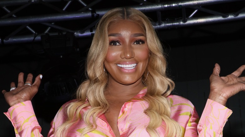 Nene Leakes smiling on a stage with her hands up