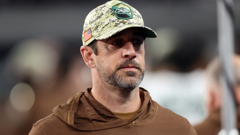 Aaron Rodgers wearing Jets merchandise on field