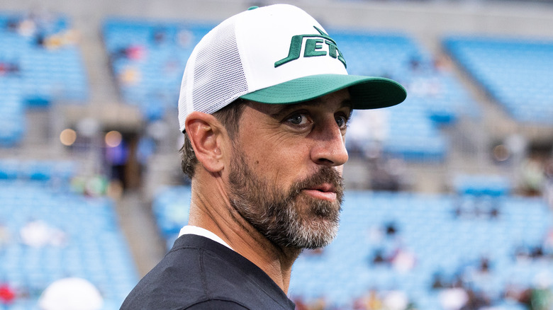 Aaron Rodgers wearing Jets cap in stadium