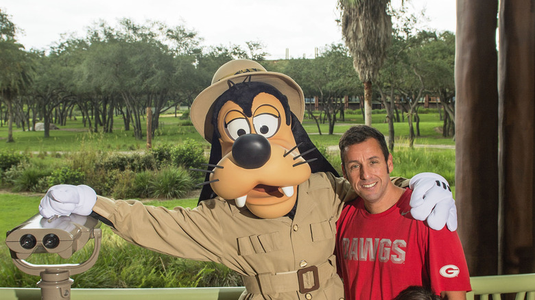 Adam Sandler poses with Goofy