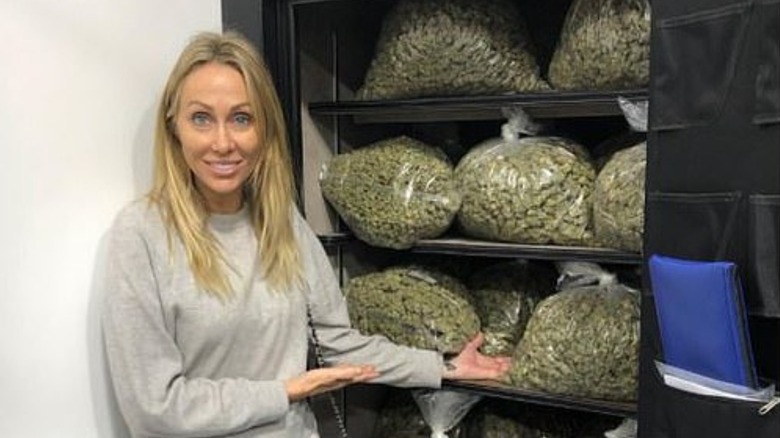 Tish Cyrus poses next to bags of marijuana