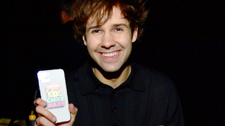 David Dobrik smiling, holding phone 