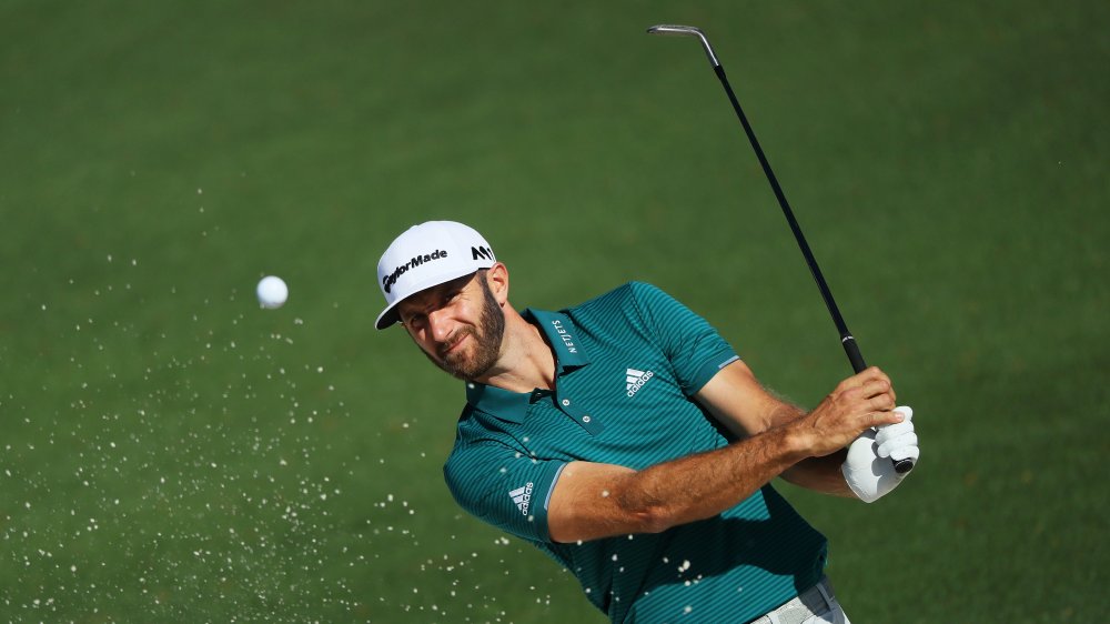 Dustin Johnson golfing in a green striped polo