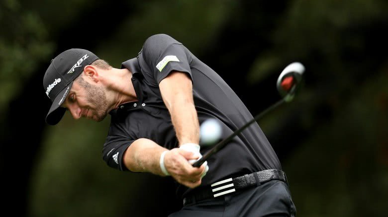 Dustin Johnson golfing in a black polo